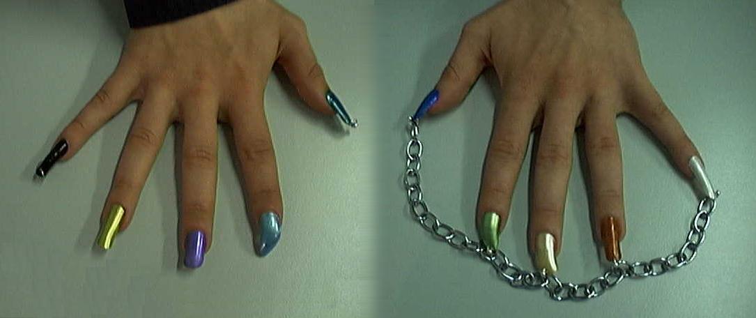 They're long, painted in various colours, and have rings attached.  Sometimes the nails on the left hand are connected by a chain.